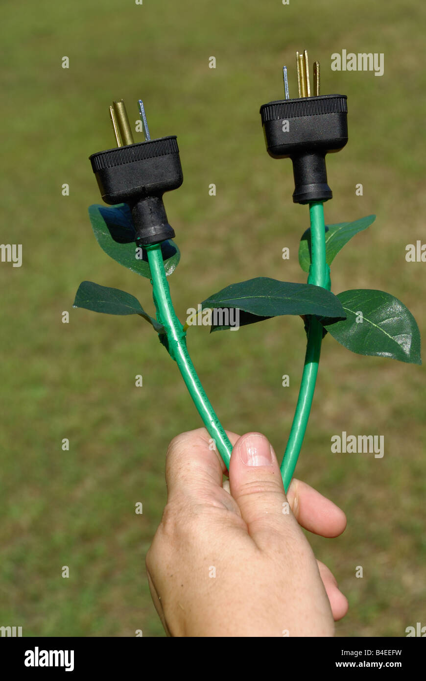 Konzeptionelle grüne Energie-Bild zeigt eine Person, die elektrischen Stecker, die aussehen wie Blumen Stockfoto