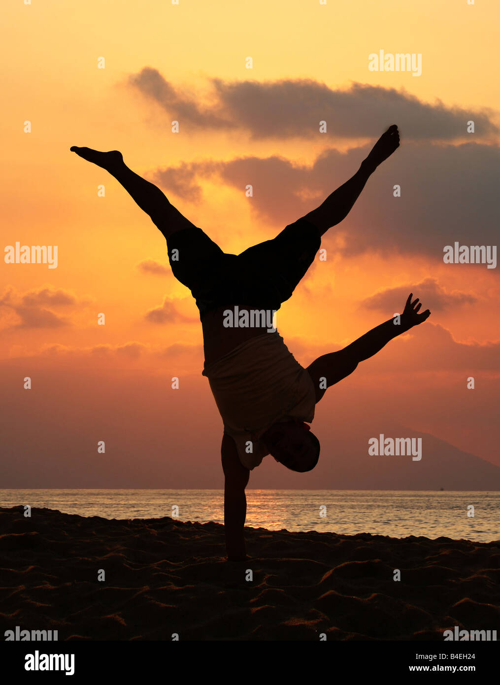Junger Mann tut eine erstaunliche Handstand bei Sonnenuntergang Stockfoto
