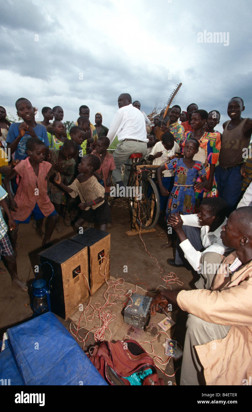 Dorfbewohner Radiohören Pedal-angetriebene in Uganda. Stockfoto