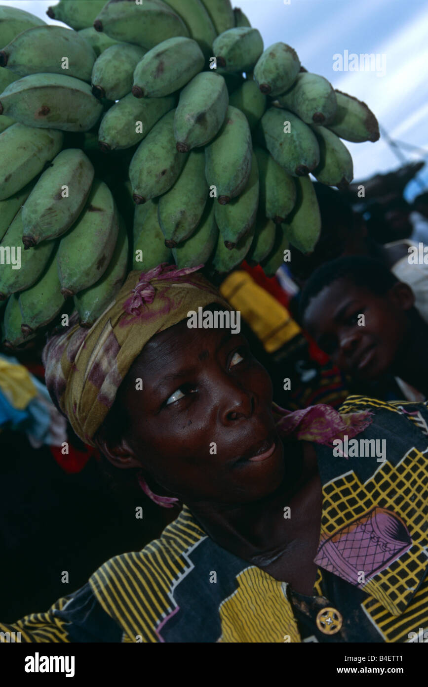 Banane Anbieter mit grüner Banane Bündel auf dem Kopf. Uganda. Stockfoto