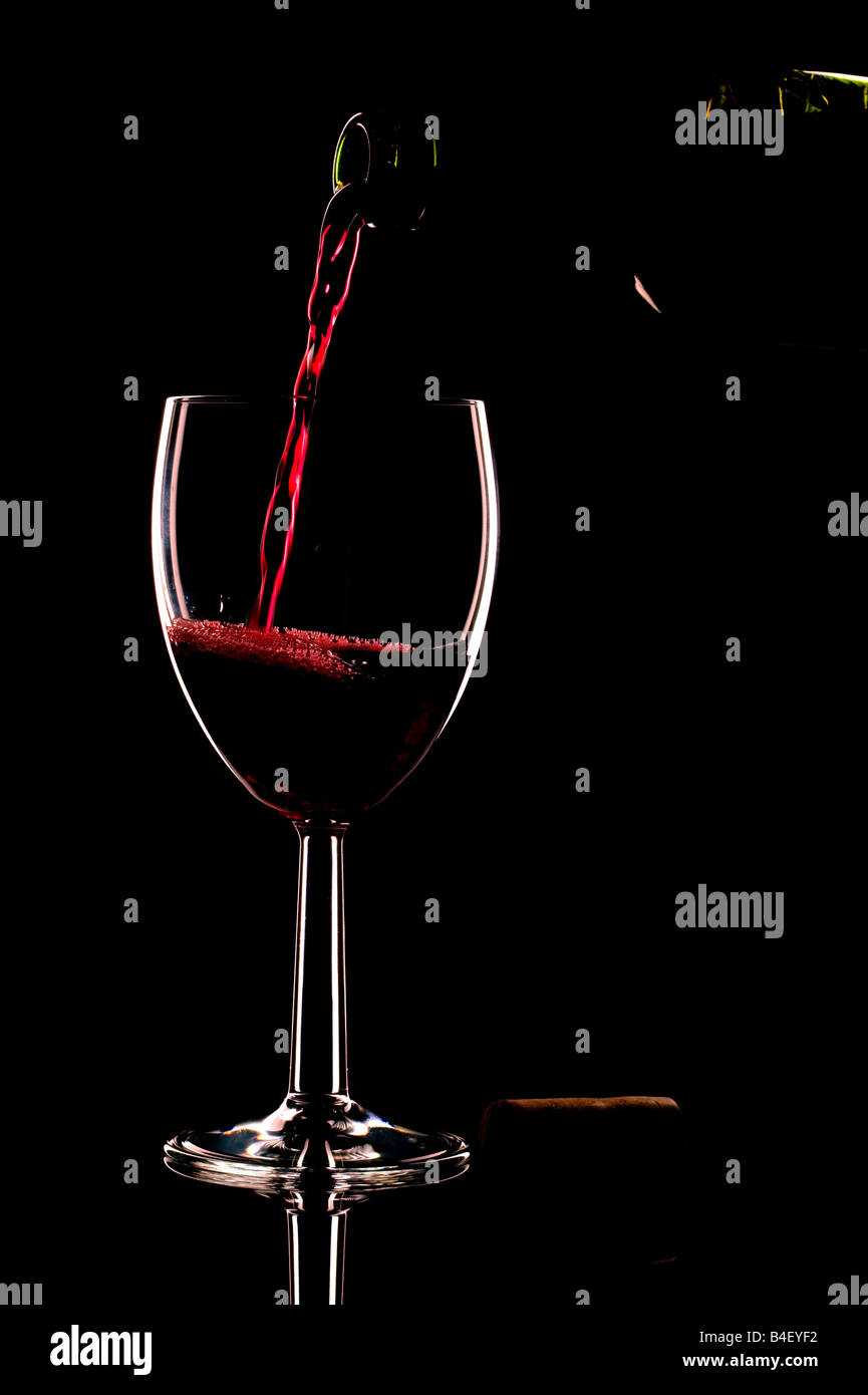 Rotwein in einem Glas auf einem schwarzen Hintergrund Stockfoto