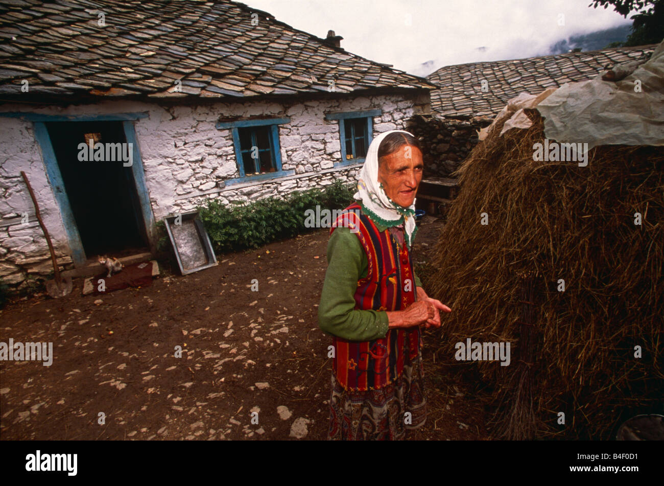Ältere Frau, die traditionelle Kleidung außerhalb whitewash Ferienhaus in Dorf, Kukes, Albanien, Südosteuropa Stockfoto