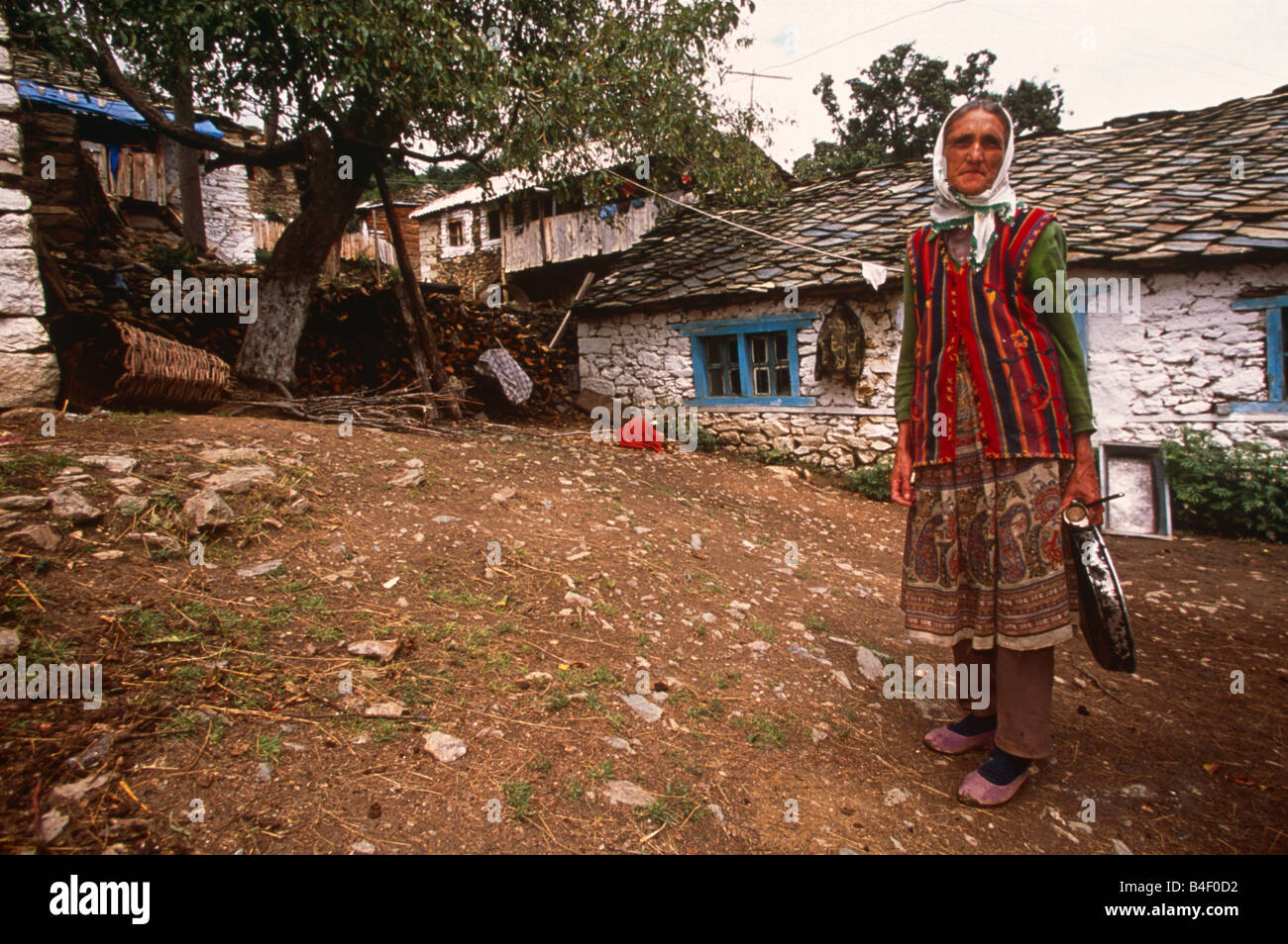 Ältere Frau, die traditionelle Kleidung außerhalb whitewash Ferienhaus in Dorf, Porträt, Kukes, Albanien, Südosteuropa Stockfoto