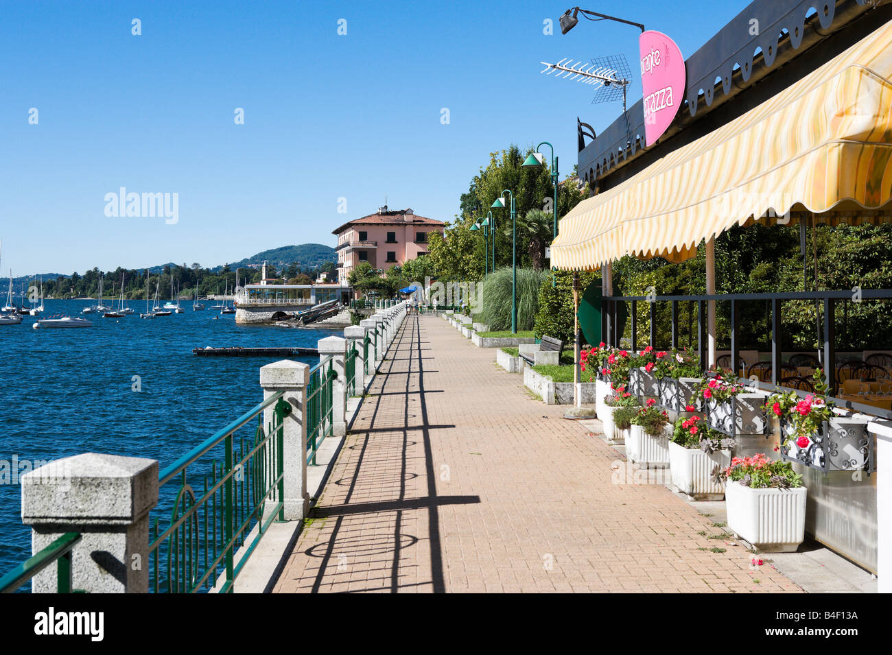 See im Zentrum des Ferienortes Belgirate mit Best Western Hotel Milano in der Ferne, Lago Maggiore, Italien Stockfoto