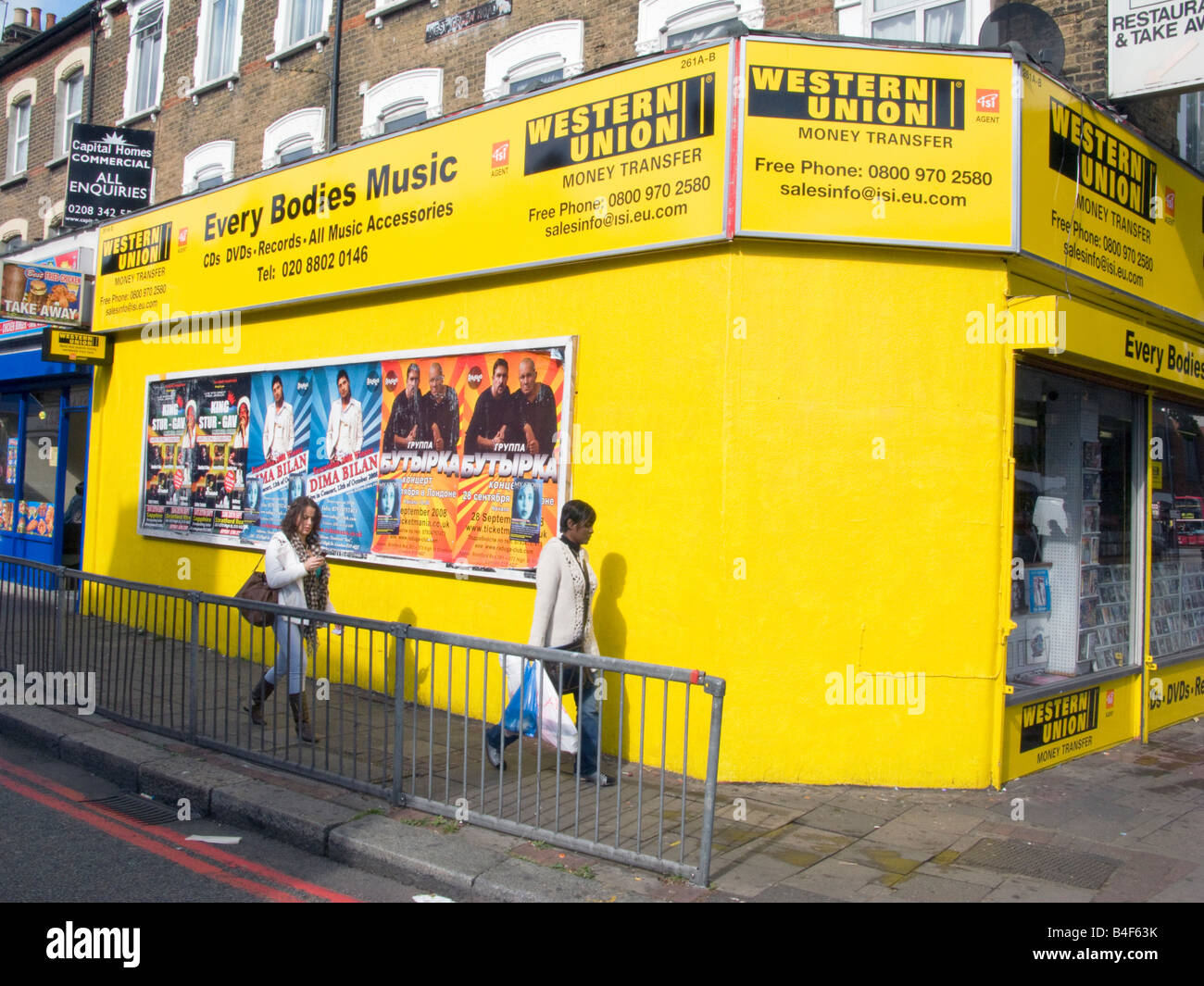 Einheimischen zu Fuß vorbei an Devisen WESTERN UNION MONEY TRANSFER SHOP IN  TOTTENHAM, LONDON Foto © Julio Etchart Stockfotografie - Alamy