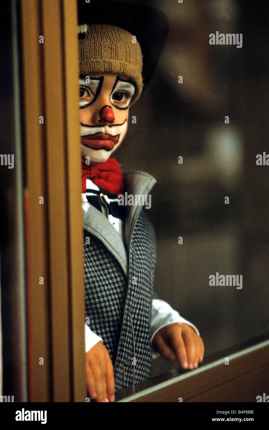 Traurige kleine Clown Blick auf das Fenster Stockfoto
