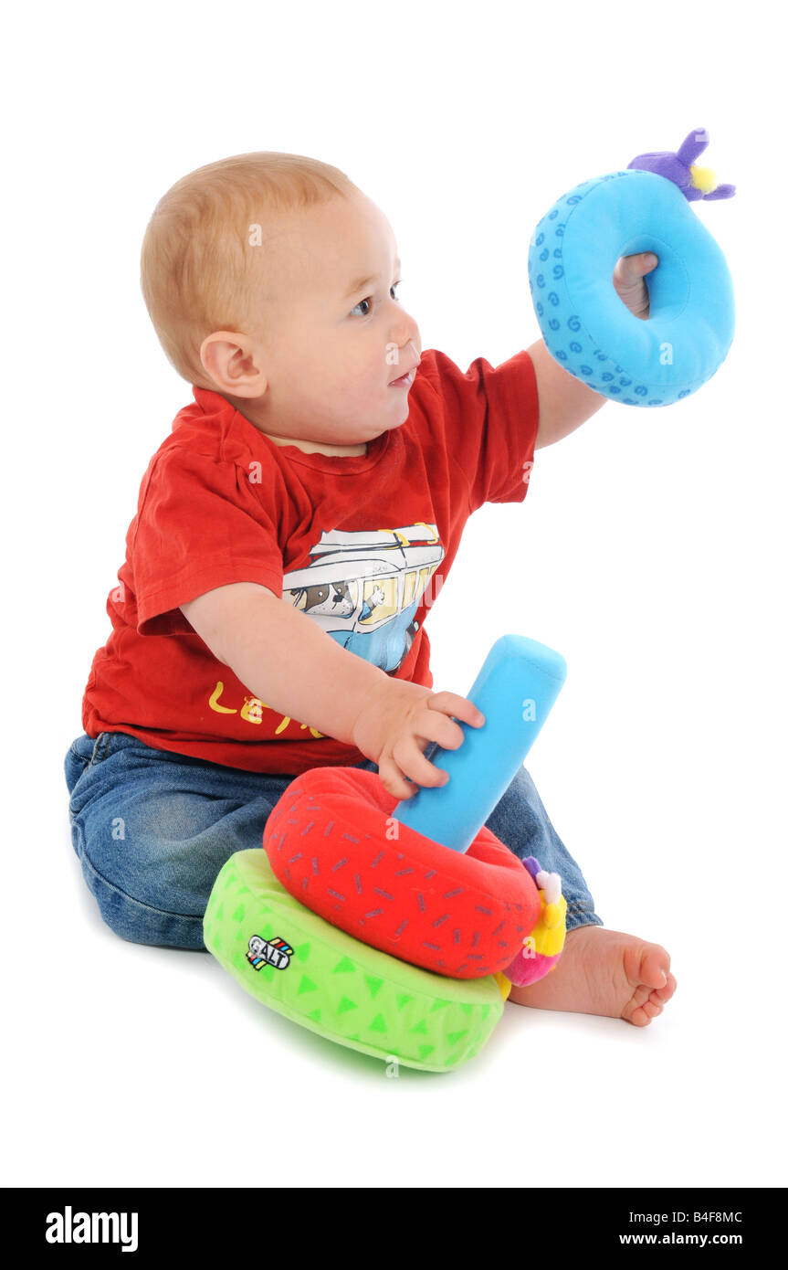 Ein Baby, das das Aufsitzen, Krabbeln und Spielen mit Spielzeug lernt. Entwicklung des frühen Lebens Stockfoto