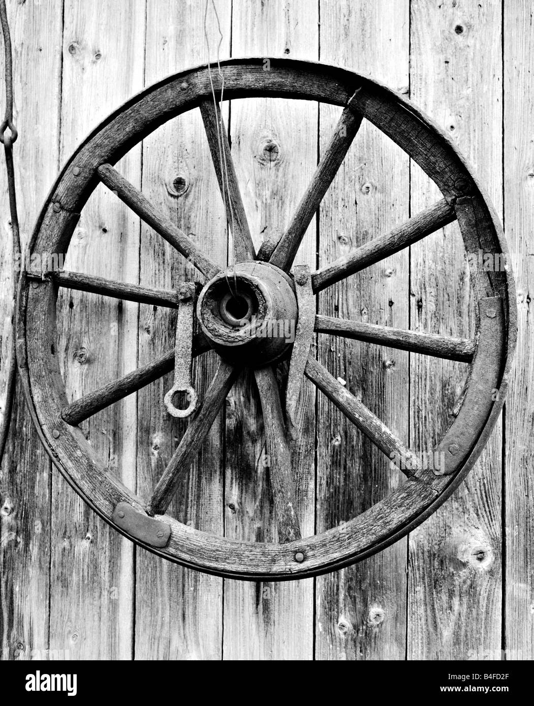 Alte hölzerne Wagen Rad an die Wand hängen Stockfoto