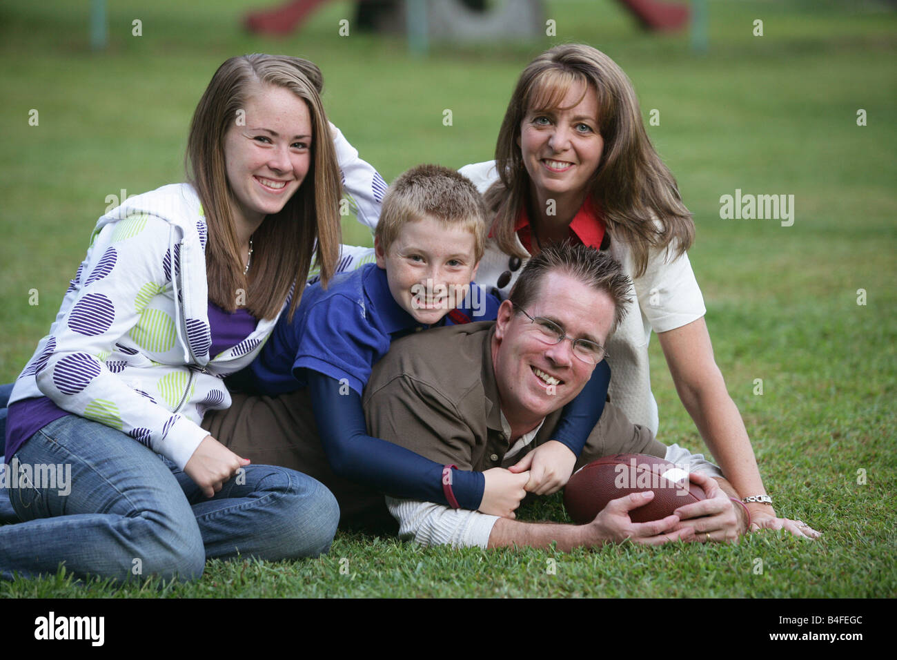 Glückliche Familie mit einem Sohn und einer Tochter Vater und Mutter auf der Rückseite Hof zu Hause mit dem Fußball Stockfoto