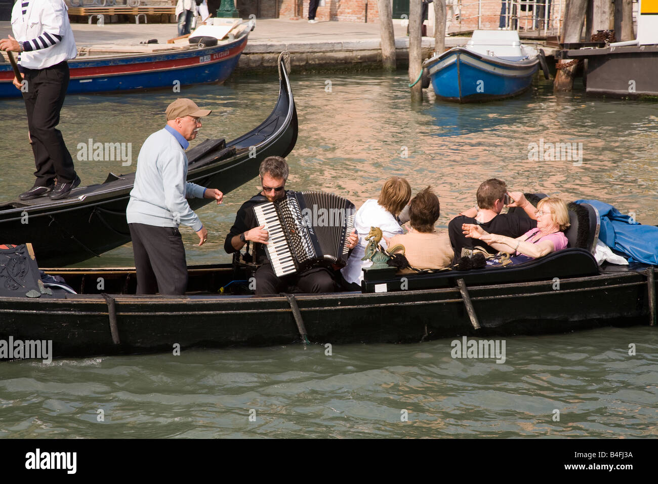 Touristen genießen eine Gondel Kreuzfahrt mit Akkordeon Begleitung, Venedig Italien Stockfoto