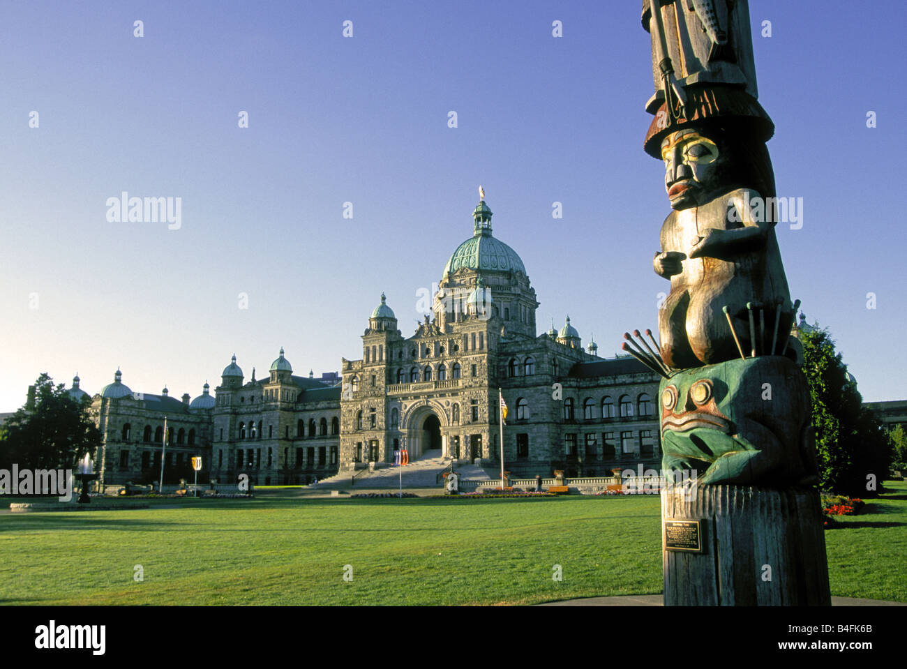 Ein Blick auf das Parlamentsgebäude und eine indische Totempfahl auf den Victoria Hafen, Victoria, Britisch-Kolumbien, Kanada. Stockfoto