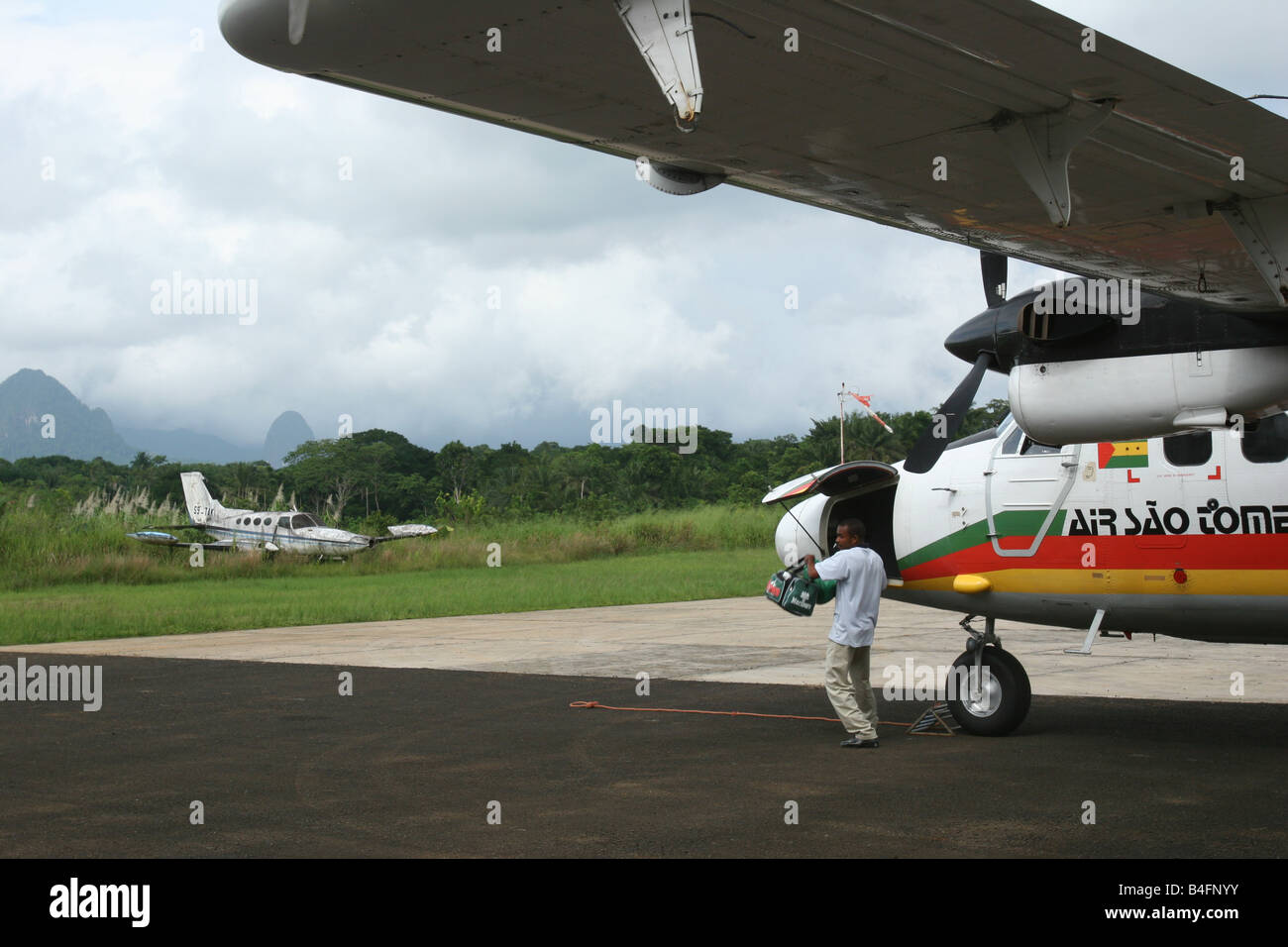 Mann, ist Gepäck aus dem Flugzeug in Principe Flughafen, eine Insel der Demokratischen Republik von São Tomé und Príncipe. Stockfoto