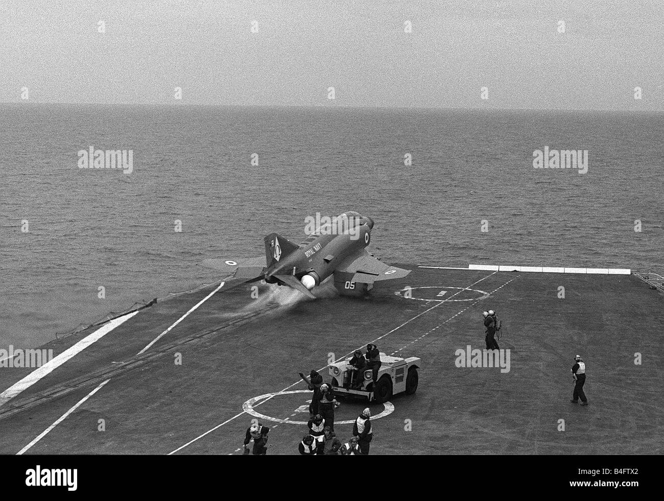 Die Decksmannschaft an Bord HMS Ark Royal schützen ihre Ohren wie eine McDonnell Douglas Phantom FG1 F 4 K der 892 Sqd FAA Donner aus mit voller Nachbrenner auf ausziehen Stockfoto