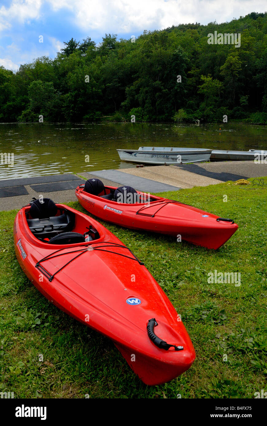 Zwei rote Kajaks sitzen am Ufer in der Nähe der See am Nordpark, Pittsburgh, Pennsylvania. Stockfoto