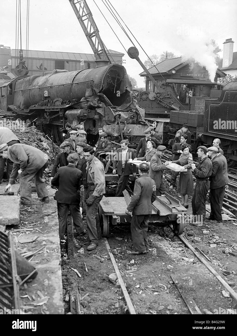 Wrack der abgestürzten Express-Züge, die die Strecke und Plattformen um Egge und Wealsden Station auf der West Coast Line unser Bild zeigt britische Schiene Ingenieure beschäftigt, klare Linie, die eine Tee Pause, wie ein Kran eine der abgestürzten Lokomotiven von der Linie im Oktober 1952 hebt Wurf Stockfoto