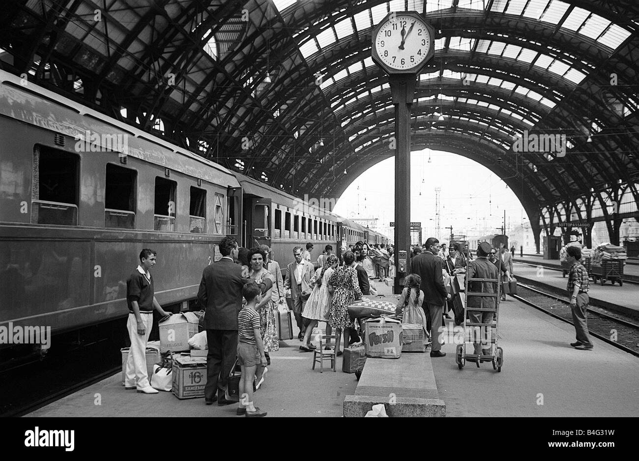 Passagiere warten, um das Rom Express am Mailänder Hauptbahnhof Juli 1962 an Bord Stockfoto