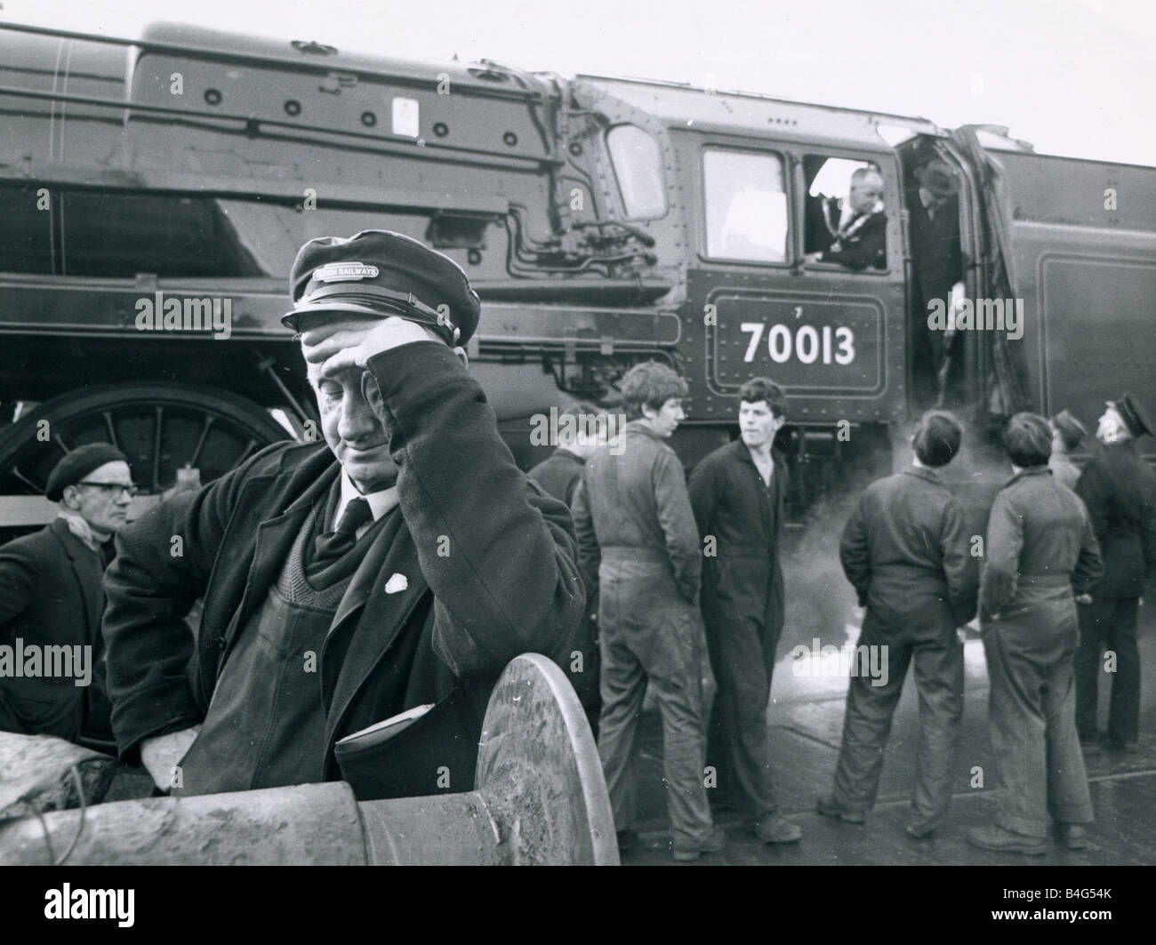 Lokführer Charles Carter hat sich abwenden, da Steam Train 70013 Oliver Cromwell die letzte Dampflok, die erhalten eine komplette Überholung bei einem British Rail-Workshop hilft der Bürgermeister wird von Crewe Stadtrat Herbert Vernon Fahrt der Zug aus den Werken zum letzten Mal Stockfoto