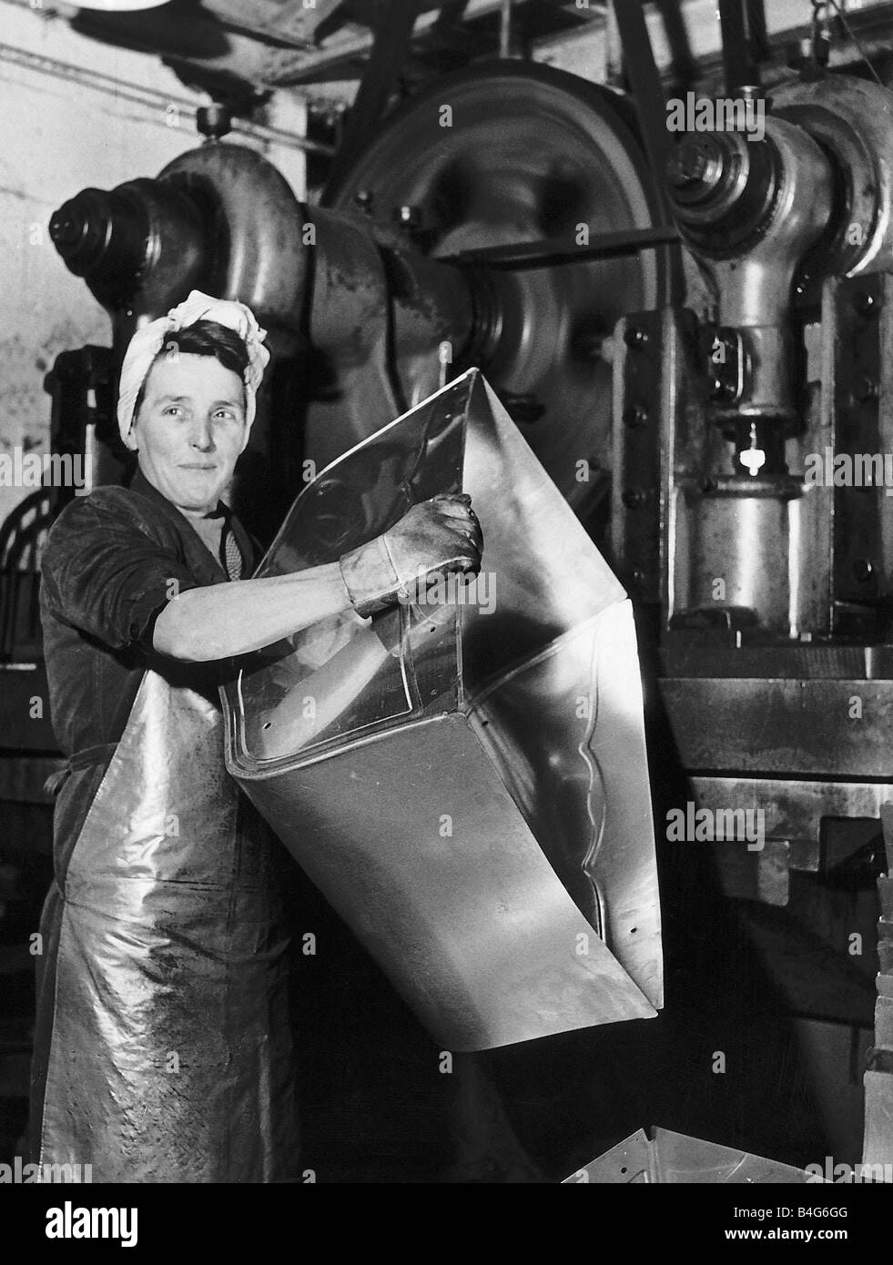 Lily Hill in ihrem riesigen Presse Stempeln aus Metall Grundlagen der Baby Kinderwagen in einer Fabrik in Morden Surrey Dezember 1947 Stockfoto