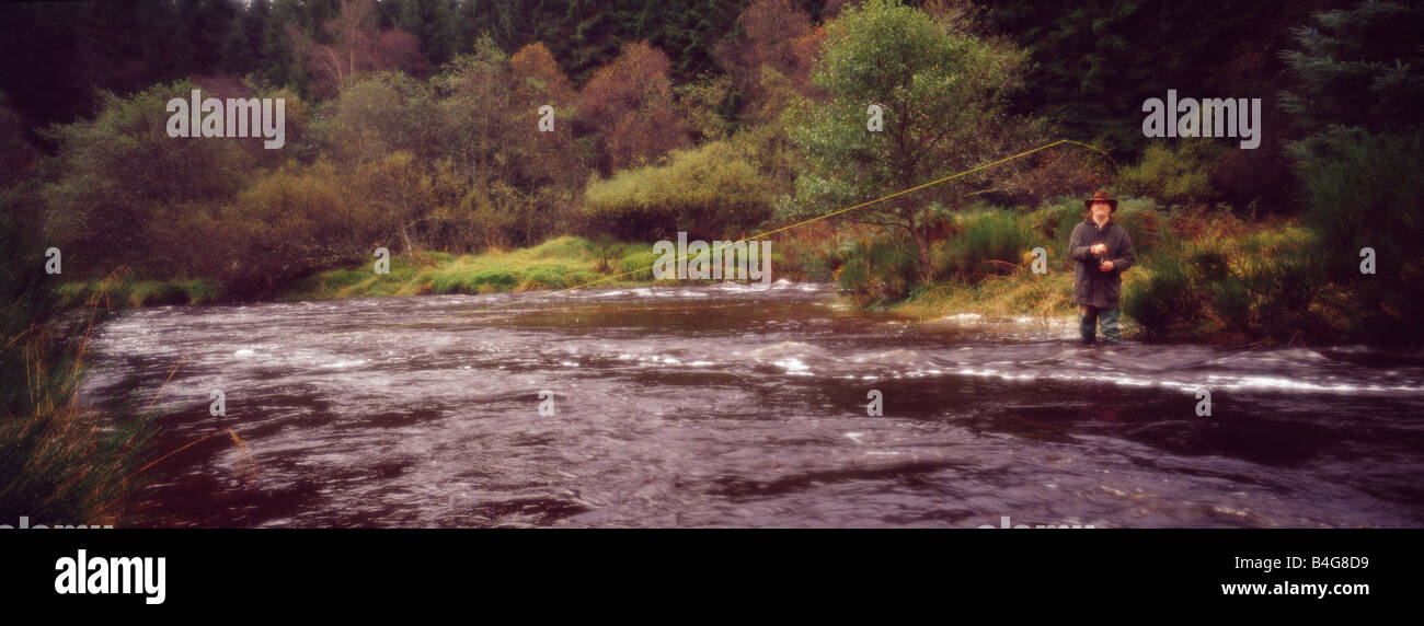 Eine Panorama-Aufnahme eines Mannes, der sein könnte ein Wilderer oder ein Spiel Torwart stehend in einem schnell fließenden Strömen in Schottland Fliegenfischen Stockfoto