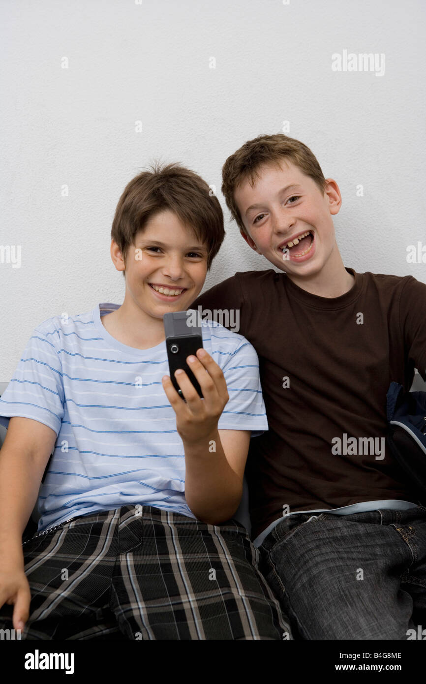 Zwei Pre-heranwachsenden Jungen Blick auf ein Mobiltelefon Stockfoto