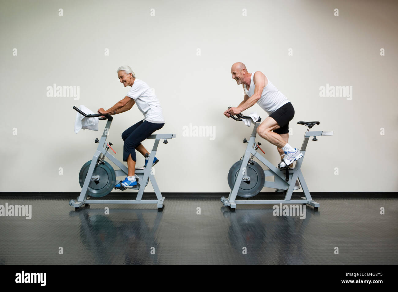 Eine ältere Frau und ein reifer Mann Reiten Heimtrainer Stockfoto