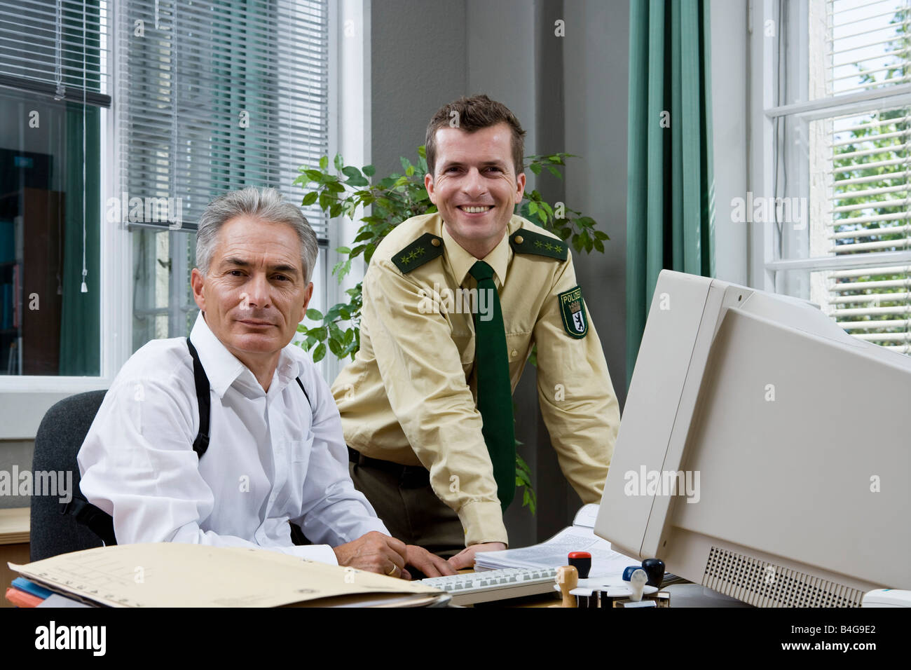 Zwei Polizisten, die in einem Büro arbeiten Stockfoto