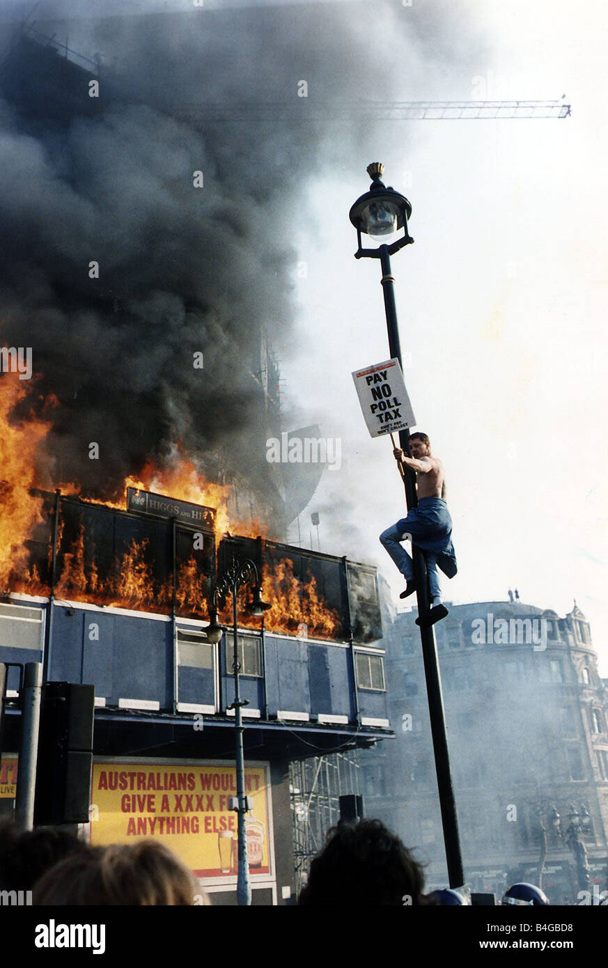 Ein Demonstrant klettert einen Laternenpfahl während der Demonstrationen gegen die Kopfsteuer Trafalgar Square die eskalierte zu einem Aufruhr Stockfoto