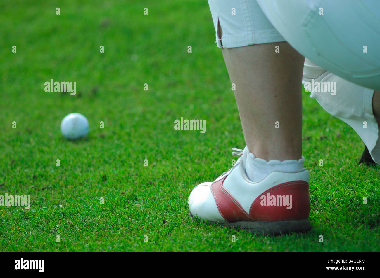 Eine junge Frau Golfspieler vor der Fahrt eines Put auf einem grünen Golfplatz Coaching Stockfoto