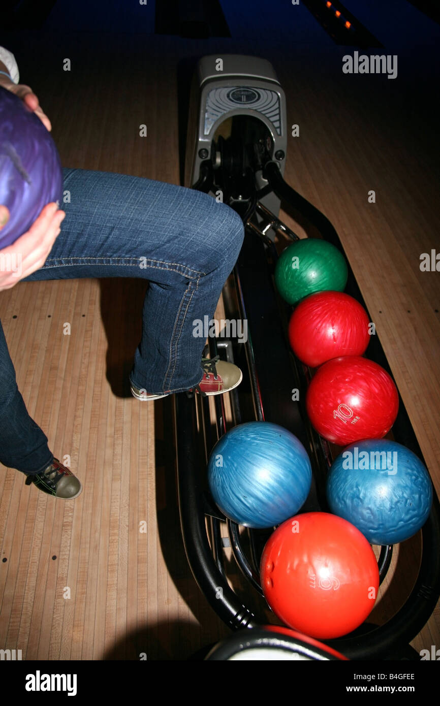 Frau Bein verstärkt auf Bowling-Kugel-rack Stockfoto