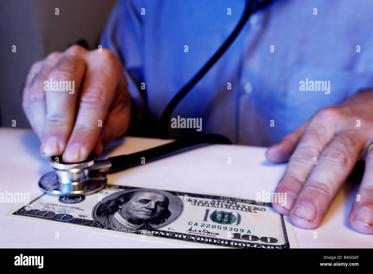 Mann mit einem Stethoskop auf einen 100 Dollar-Schein Stockfoto