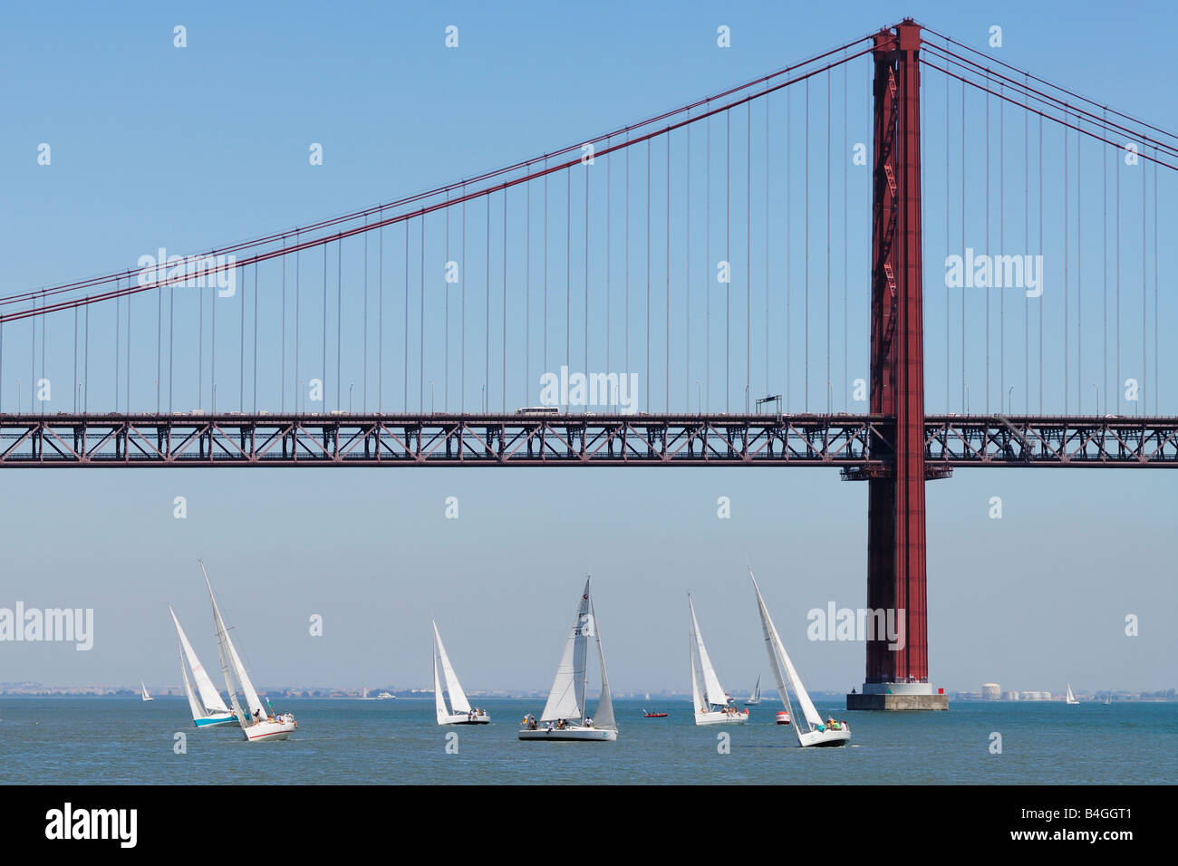 Lissabon Portugal Yachten Segeln auf den Tejo mit der Ponte 25 de Abril im Hintergrund Stockfoto