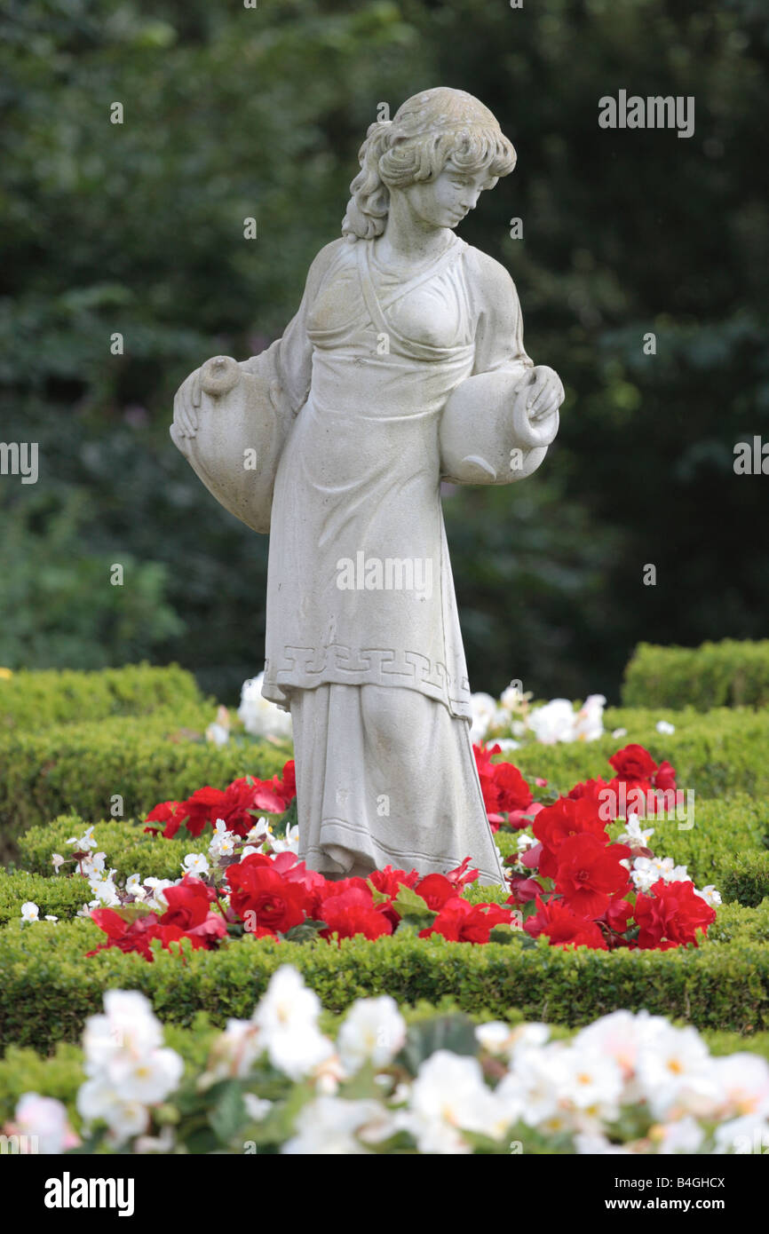 Klassische Garten Statuen eines Mädchens hält Amphore Satz innerhalb einer Box Parterre, Gatehouse of Fleet. Stockfoto