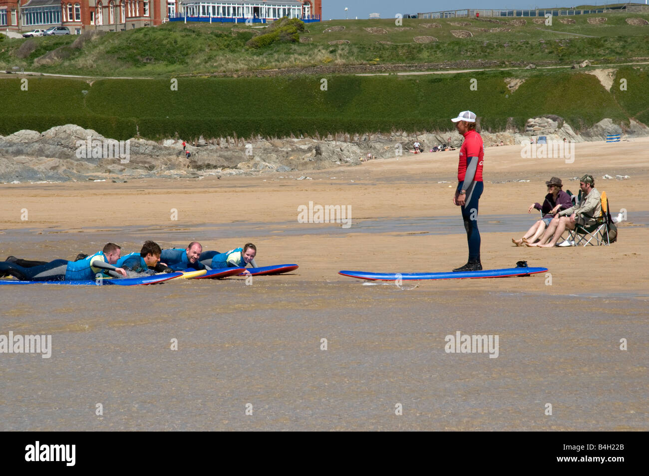 Gruppe von Freunden in Surfschule erhalten Anweisungen von einem Instruktor auf fistral Strand Newquay Cornwall Stockfoto