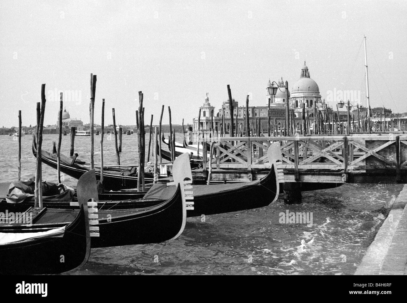 Gondeln vor Anker mit der Kirche Santa Maria della Salute in Venedig im Hintergrund Mai 1987 Mirrorpix Stockfoto