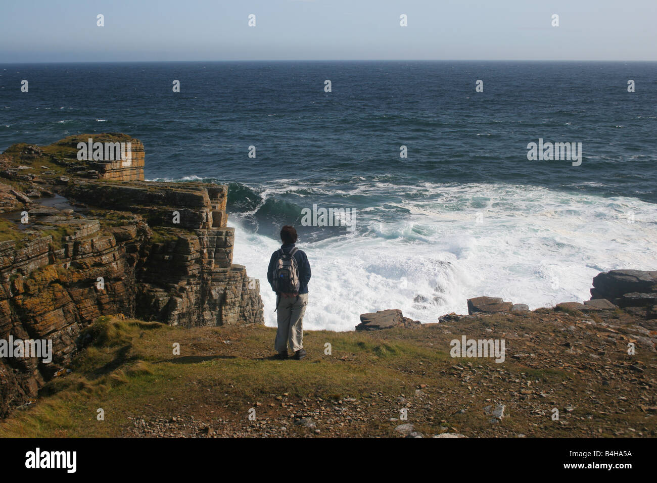 Eine Frau zu Fuß an der Küste von Deerness Orkney Inseln, Schottland Stockfoto