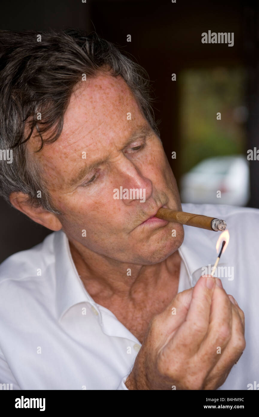 Mann mittleren Alters, raucht eine Zigarre Stockfoto