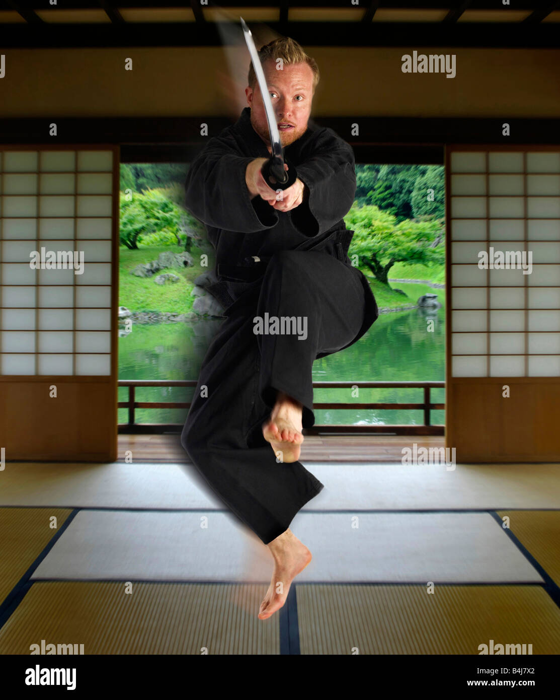 Martial Artist auffällig mit Katana im japanischen Raum Stockfoto