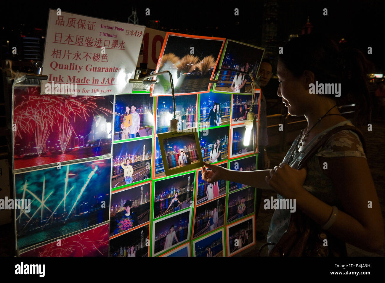 Chinesische Frau anzeigen Straßenfotograf druckt nachts Kowloon Hong Kong JMH3313 Stockfoto