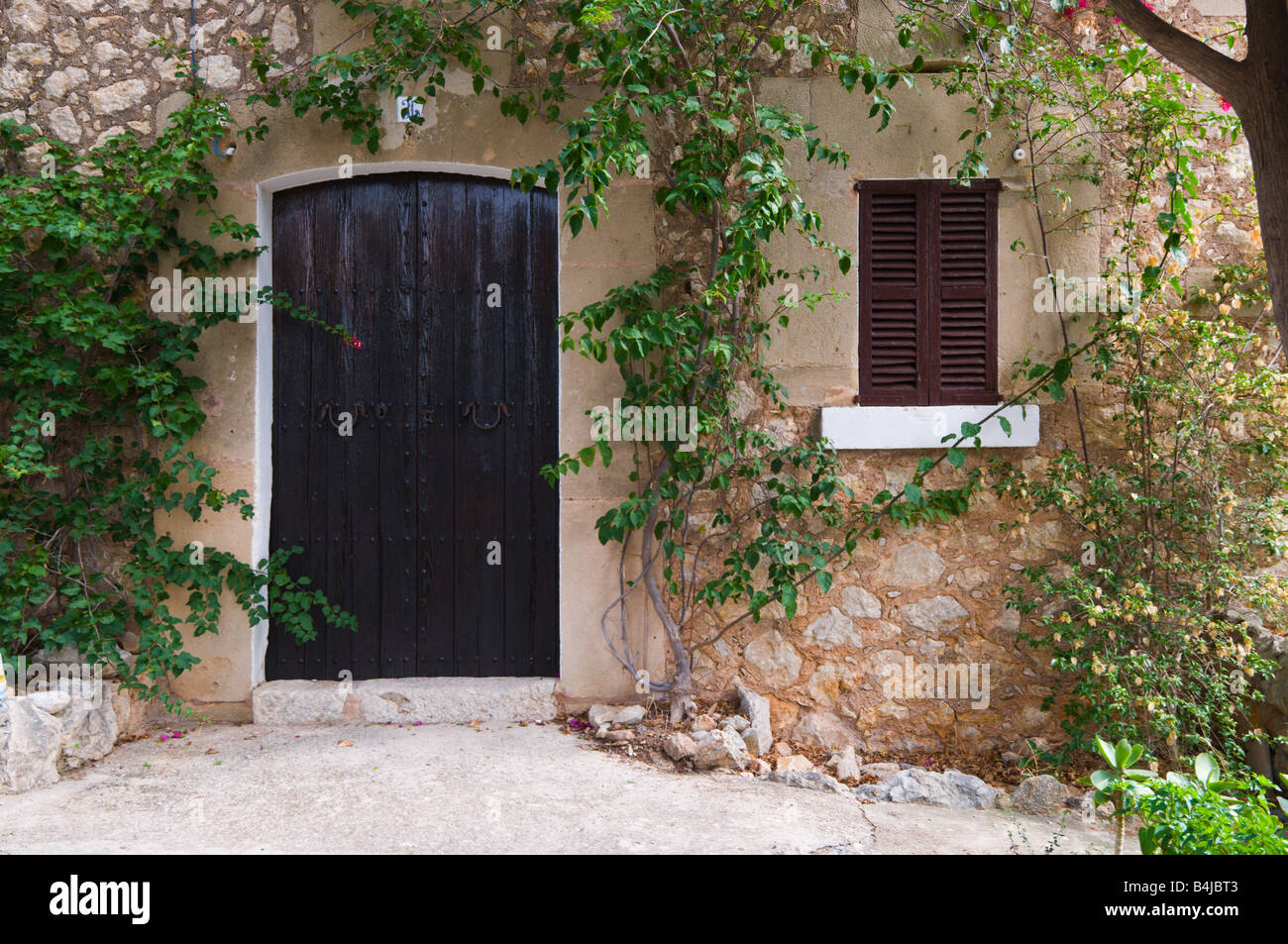 Ein altes Gebäude mit hölzernen Verschlusszeit und Tür in Pollensa, Mallorca, Spanien. Stockfoto