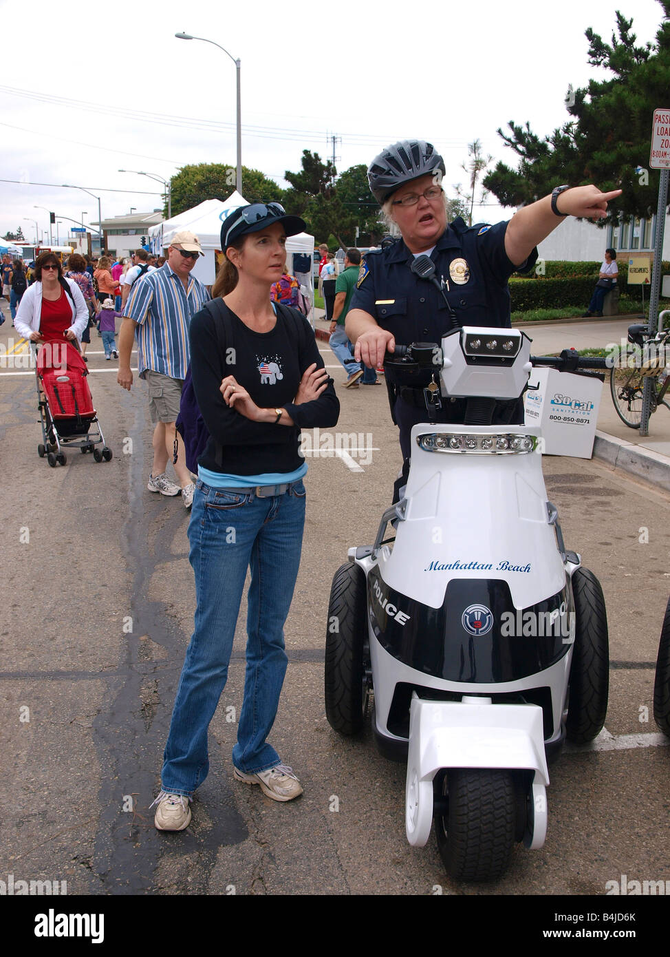 Polizistin leitet weibliche faire Teilnehmer aus ihrem T3 Motion persönliche Elektromobilität-Fahrzeugs. Stockfoto