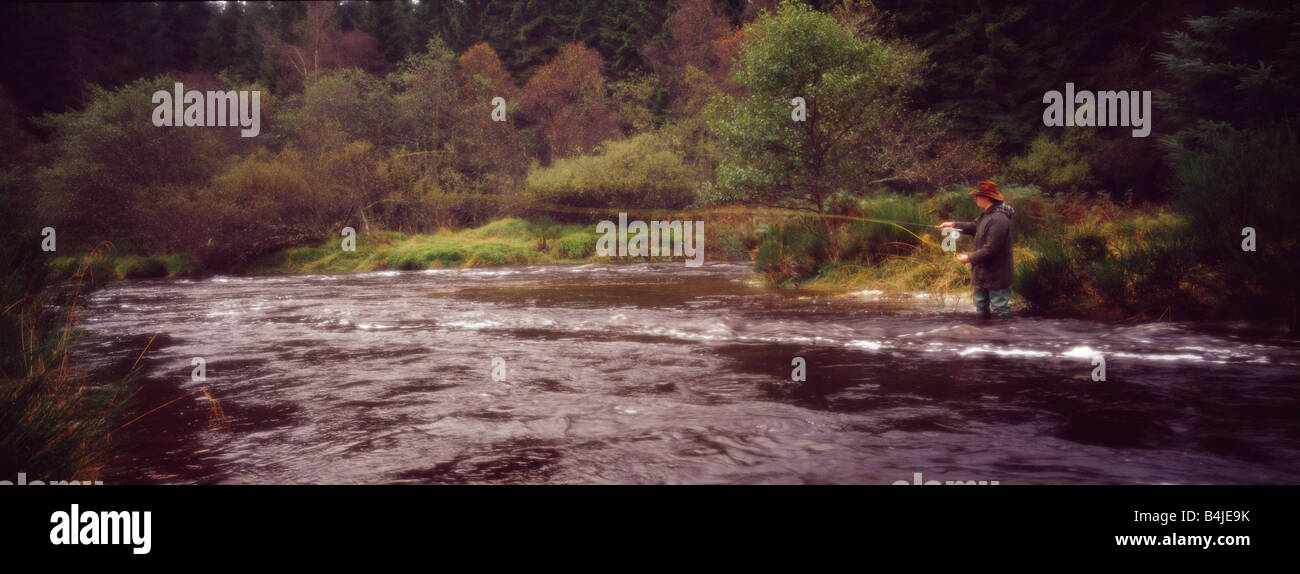 Eine Panorama-Aufnahme eines Mannes, der sein könnte ein Wilderer oder ein Spiel Torwart stehend in einem schnell fließenden Strömen in Schottland Fliegenfischen Stockfoto