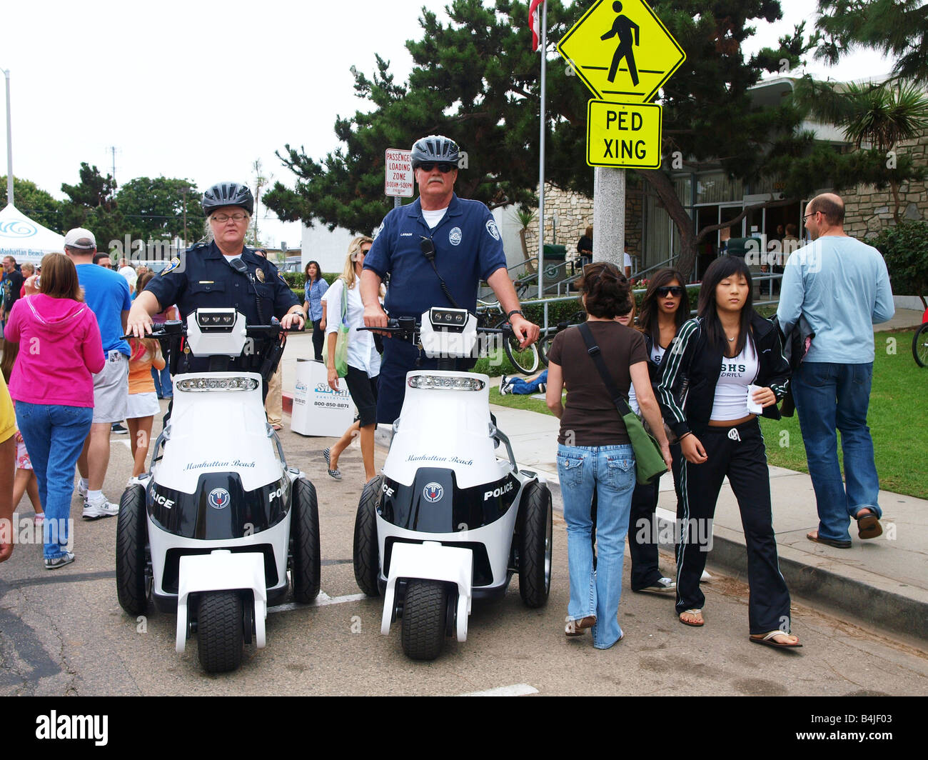 Männliche und weibliche Polizisten auf ihre T3 Motion elektrische persönliche Mobiltiy Fahrzeuge an der Manhattan Beach Home Town Fair Stockfoto