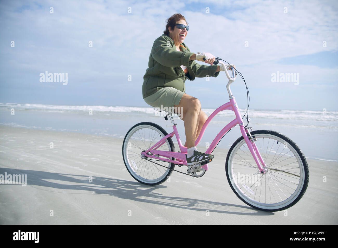 Senior Italienerin Reiten Fahrrad am Strand Stockfoto