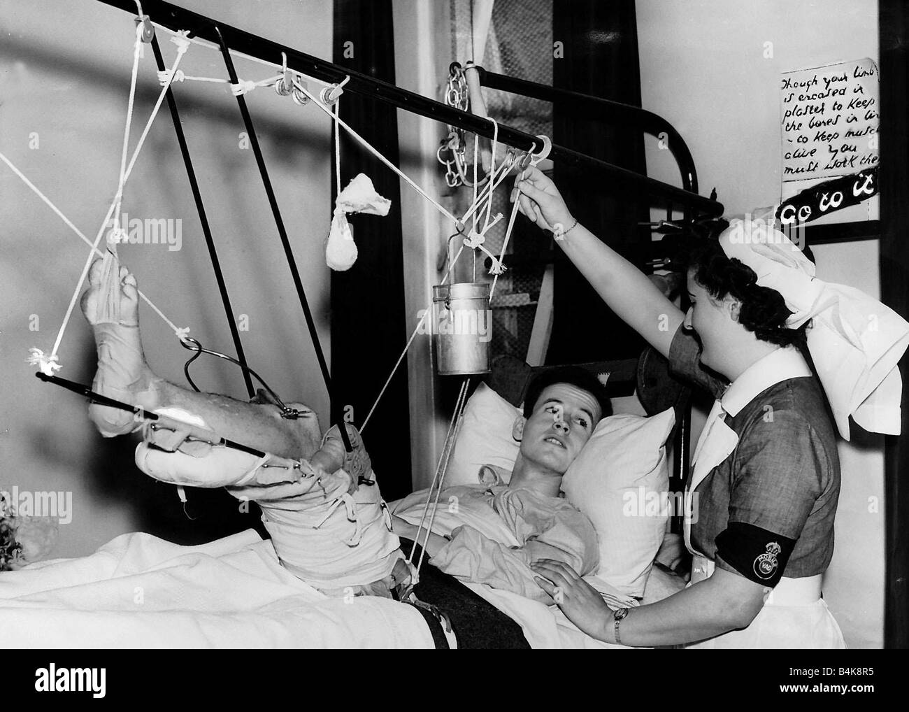 Britischer Pilot mit einem gebrochenen Oberschenkel spricht mit einer Krankenschwester von seinem Krankenhausbett WW2 1941 Stockfoto