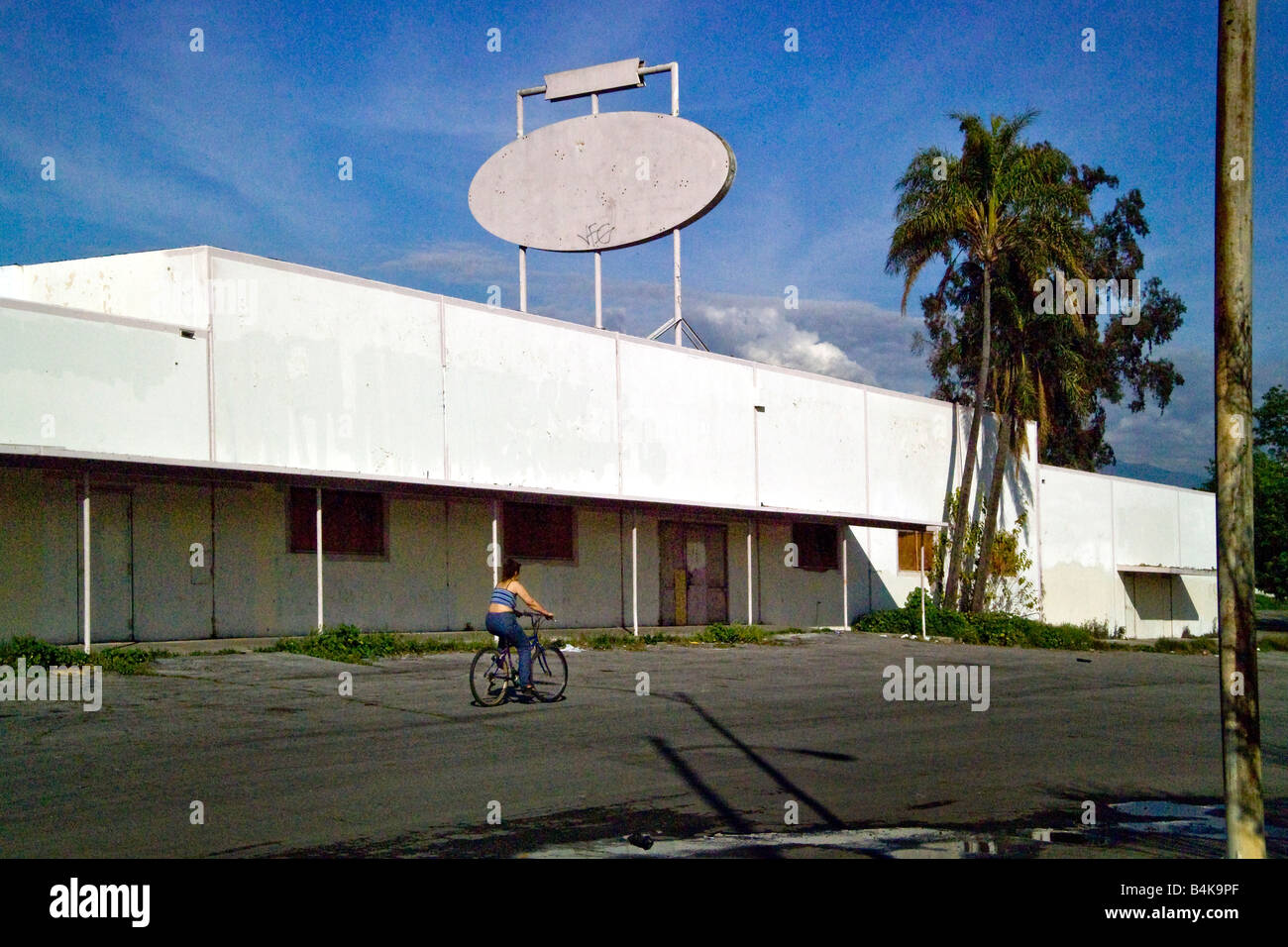 Ein spanischer Radfahrer nimmt einer Abkürzung durch ein verlassenes Shopping-Mall in San Bernardino CA ein Opfer des demografischen Stockfoto