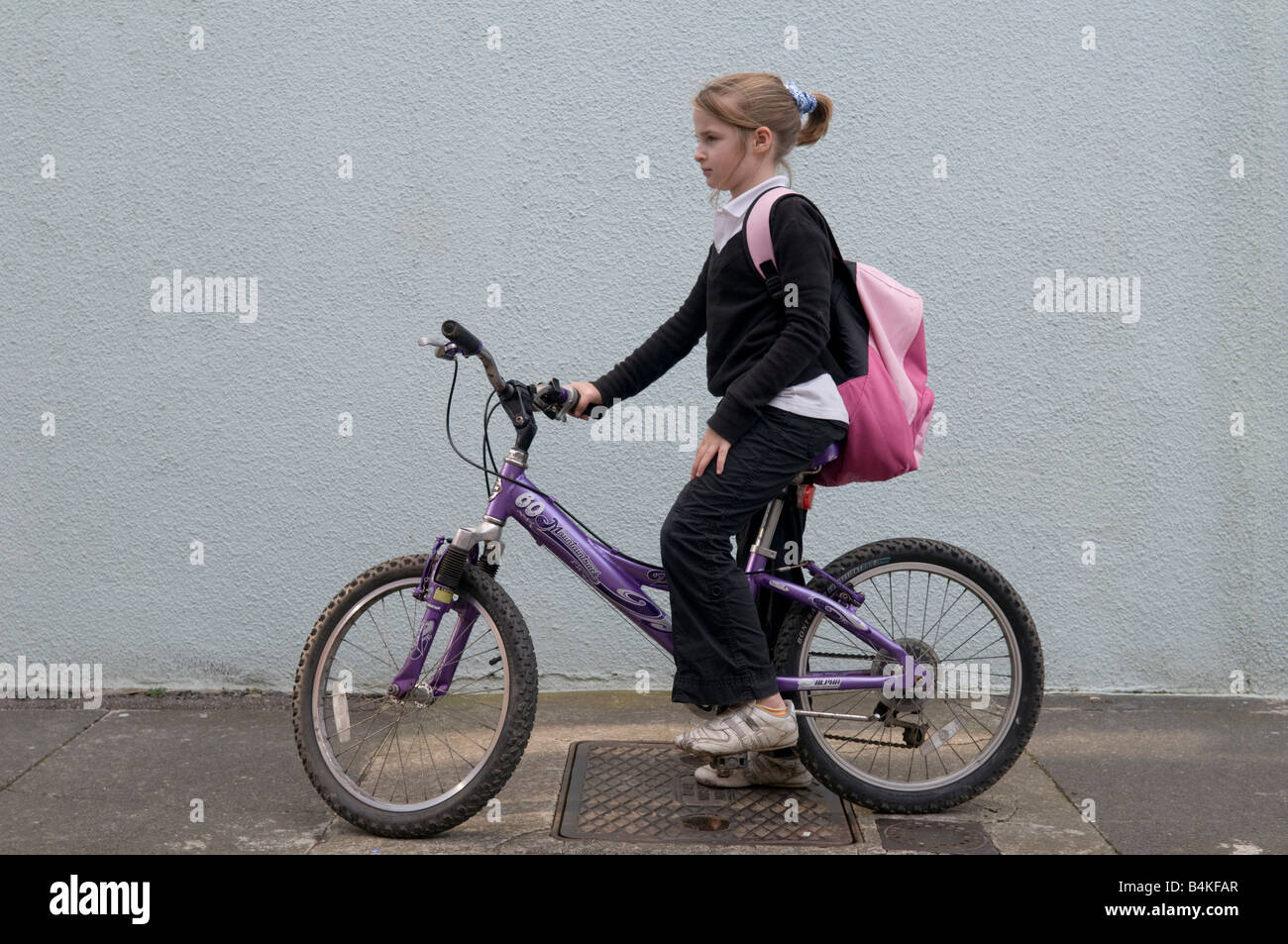 Eine 10 Jahre alte Mädchen tragen einheitliche Schule gehen zu ihrem Fahrrad UK Grundschule fahren Stockfoto