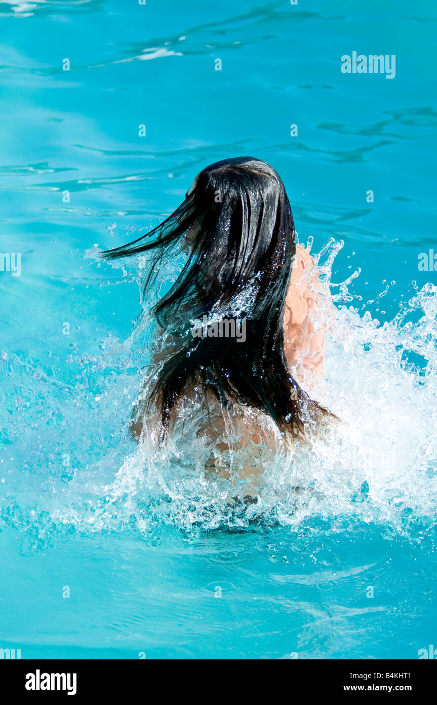 Junge Frau, die durchs Wasser schwimmen Stockfoto