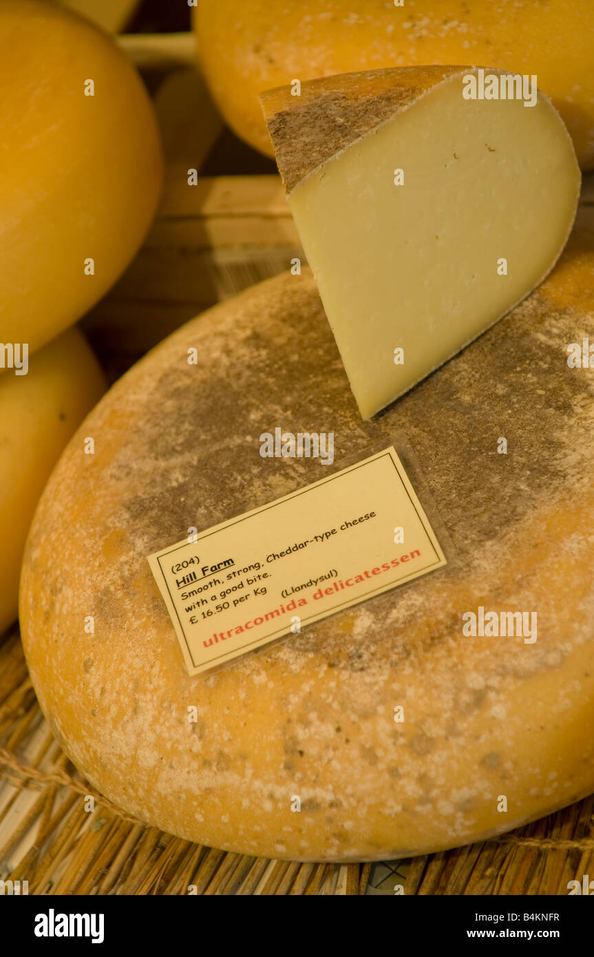 Runden und Keile Hill Farm-Cheddar-Käse aus Wales am Verkauf im Fachgeschäft Feinkost Lebensmittel lagern UK Stockfoto