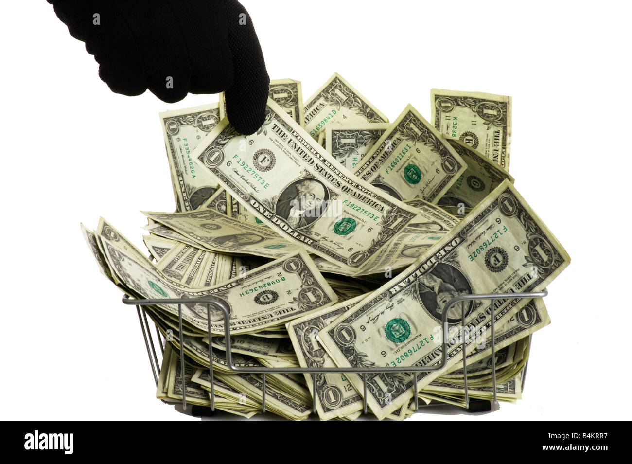schwarz behandschuhten Hand Hineingreifen in Haufen von USA-Dollar-Scheine in Büro-Drahtkorb Stockfoto