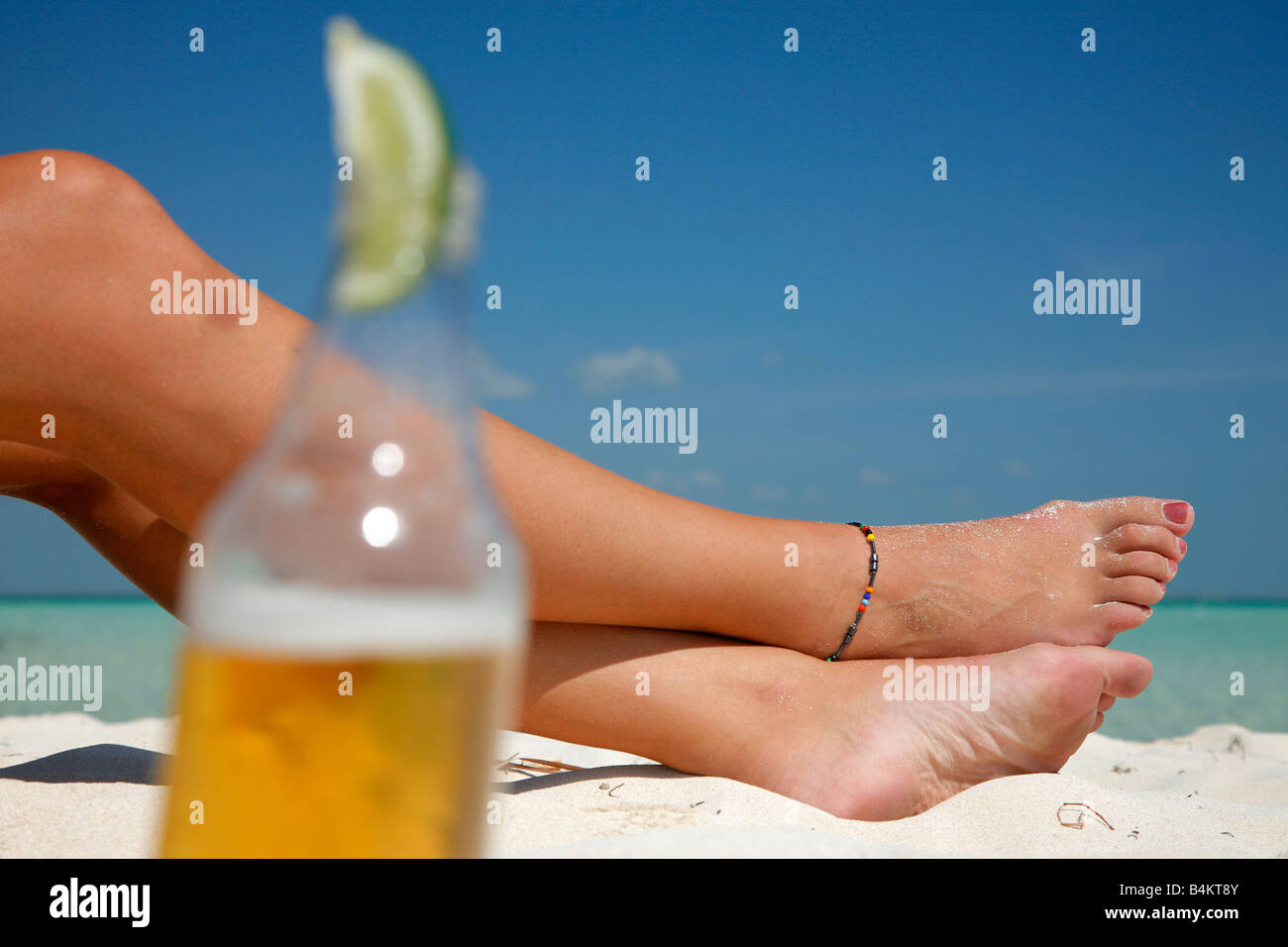 Frau die Füße mit einem mexikanischen Stil Bier im Vordergrund Stockfoto